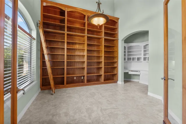 a view of a livingroom with a chandelier fan and windows