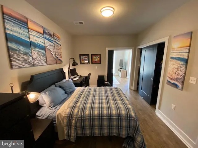 a bedroom with a bed and wooden floor