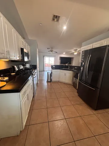 a kitchen with a sink a stove top oven a refrigerator and cabinets