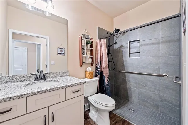 a bathroom with a granite countertop sink toilet and shower