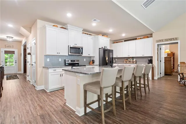 a kitchen with appliances a sink a counter top space and cabinets