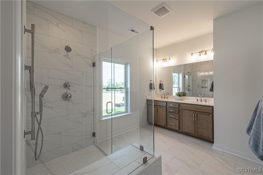 6649 Mayland Ridge Lane Moseley, VA 23120 - Photo 24 of 32 a bathroom with a granite countertop sink a mirror and a shower