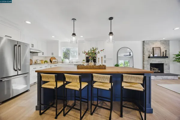 a large kitchen with stainless steel appliances kitchen island granite countertop a large counter top and wooden floors