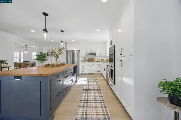 a large kitchen with stainless steel appliances kitchen island granite countertop a sink and cabinets