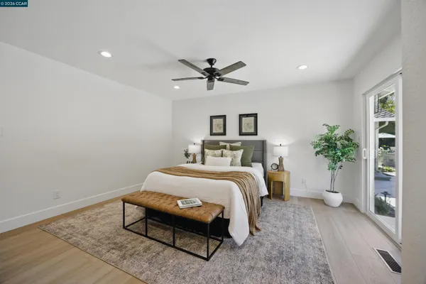 a bed sitting in a bedroom next to a window with potted plants
