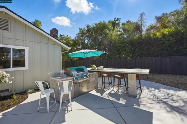 a view of a dinning table and chairs in patio of the house