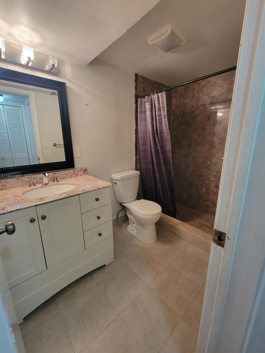 4321 Northwest 9th Avenue, Unit 102 Deerfield Beach, FL 33064 - Photo 15 of 34 a bathroom with a sink a toilet and mirror