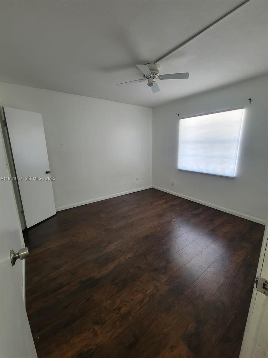 4321 Northwest 9th Avenue, Unit 102 Deerfield Beach, FL 33064 - Photo 18 of 34 an empty room with wooden floor and windows