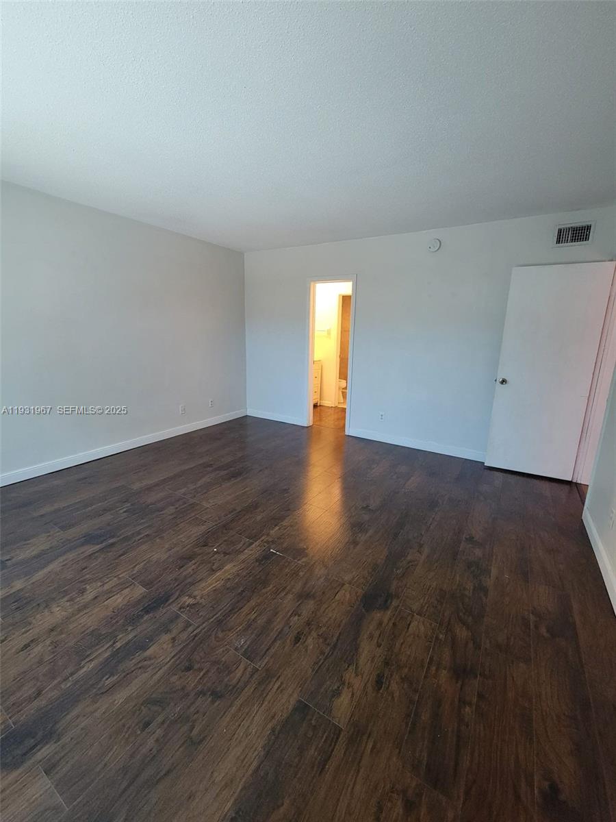 4321 Northwest 9th Avenue, Unit 102 Deerfield Beach, FL 33064 - Photo 27 of 34 a view of an empty room with wooden floor and a window
