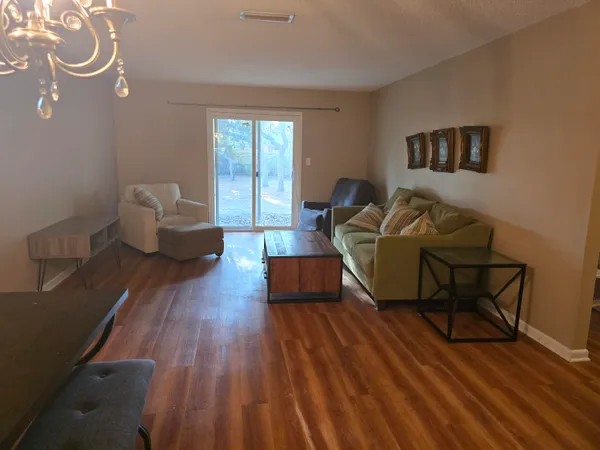 a living room with furniture and a wooden floor