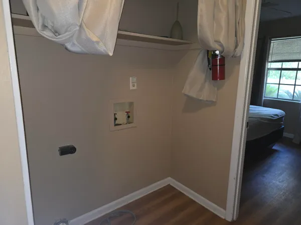 a view of a hallway with wooden floor and closet