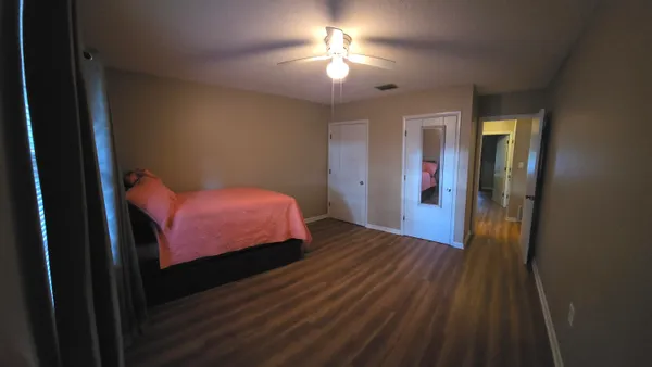 a bedroom with a bed and a chandelier fan