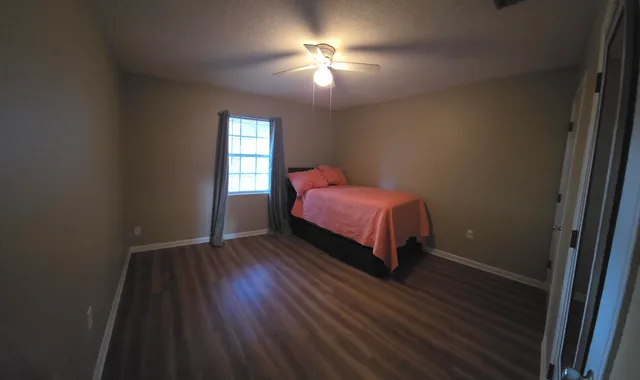 a bedroom with a bed and a window