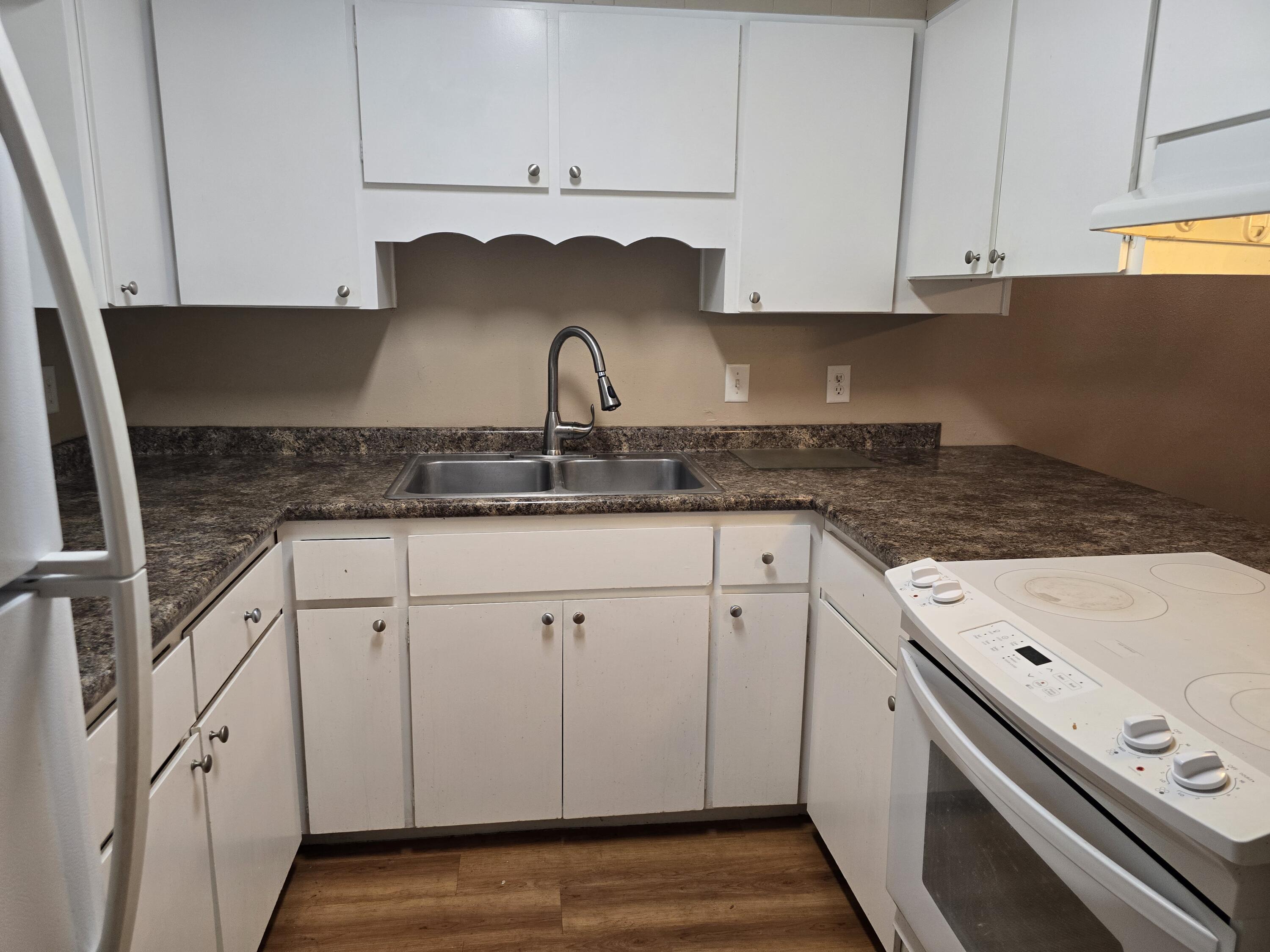 17 7th Street, Unit 2 Shalimar, FL 32579 - Photo 2 of 29 a kitchen with granite countertop a sink a stove and cabinets