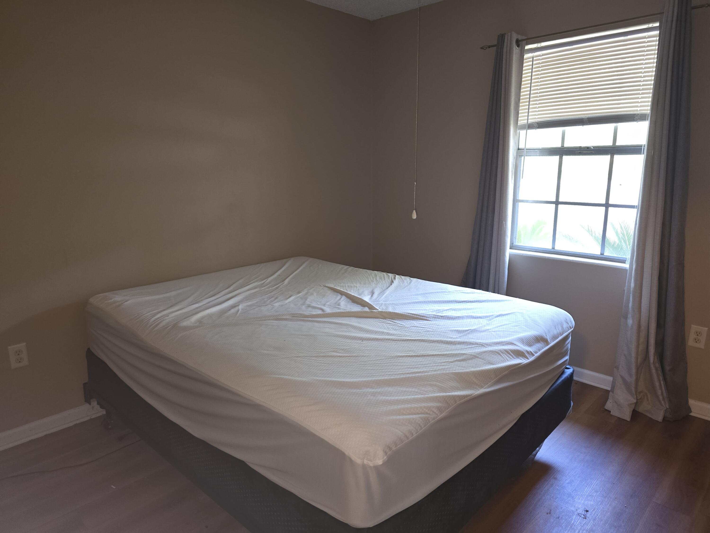 17 7th Street, Unit 2 Shalimar, FL 32579 - Photo 22 of 29 a bed sitting in a bedroom next to a window