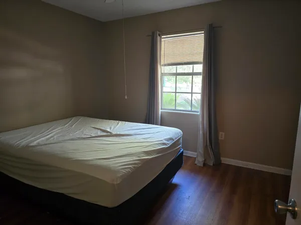 a bed sitting in a bedroom next to a window