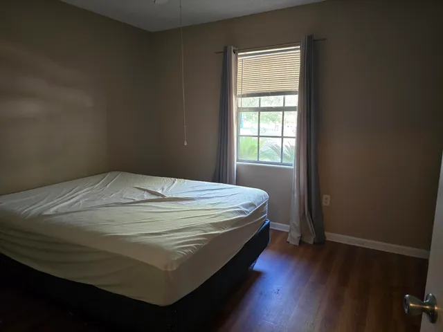 a bed sitting in a bedroom next to a window