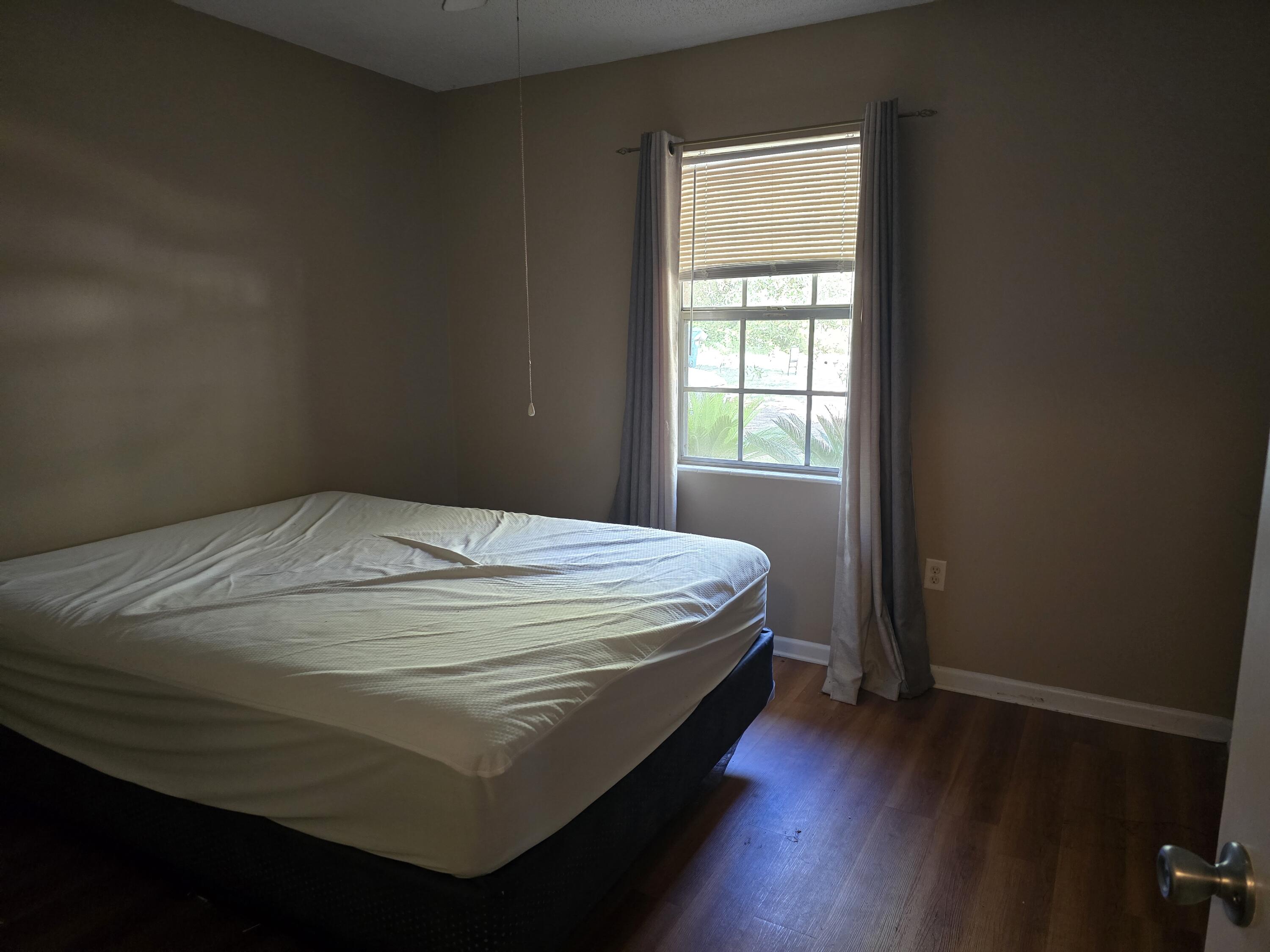 17 7th Street, Unit 2 Shalimar, FL 32579 - Photo 23 of 29 a bed sitting in a bedroom next to a window