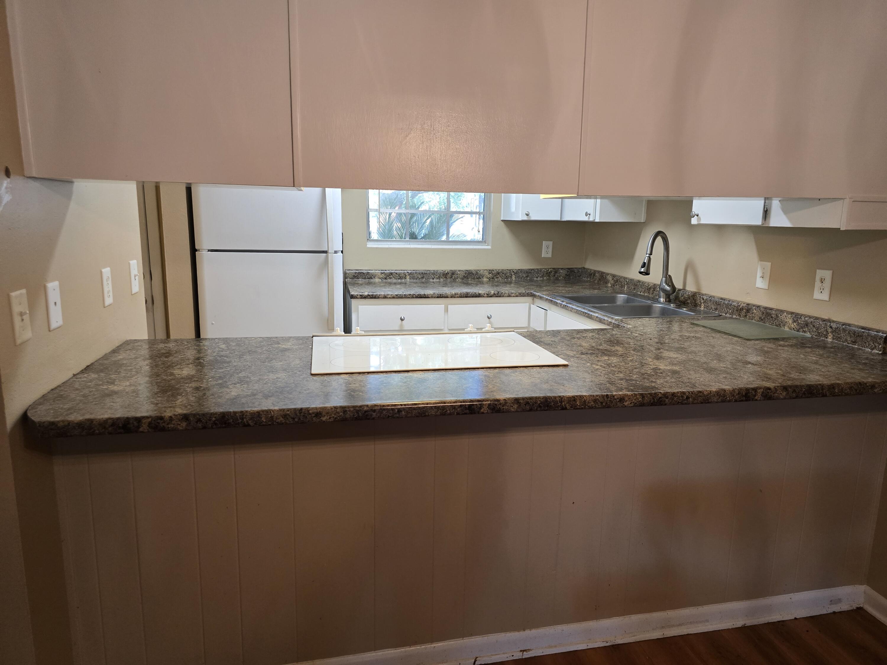17 7th Street, Unit 2 Shalimar, FL 32579 - Photo 6 of 29 a kitchen with kitchen island a sink a counter space and a refrigerator
