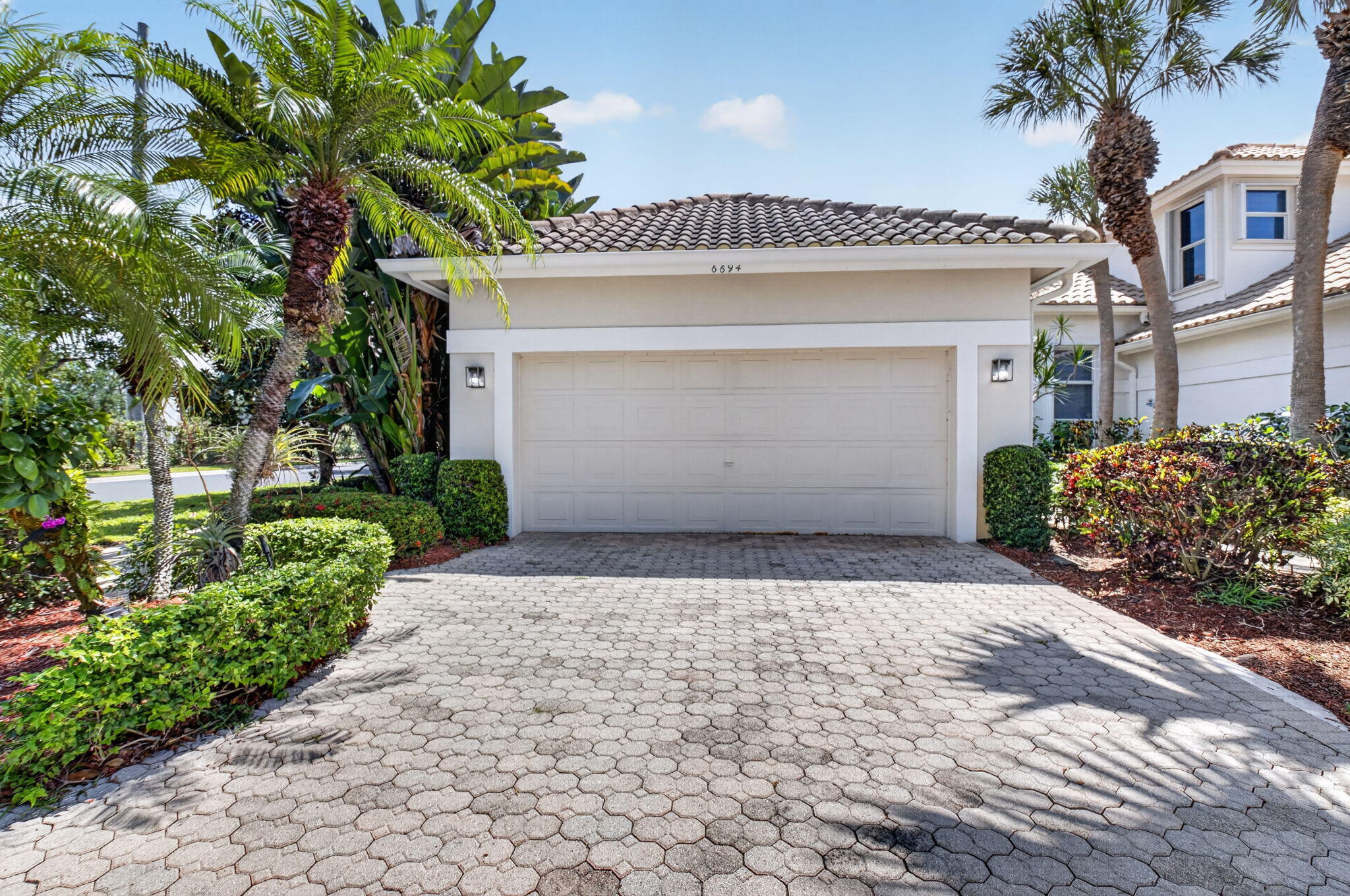6694 Northwest 26th Way Boca Raton, FL 33496 - Photo 1 of 58 a front view of a house with a yard and garage