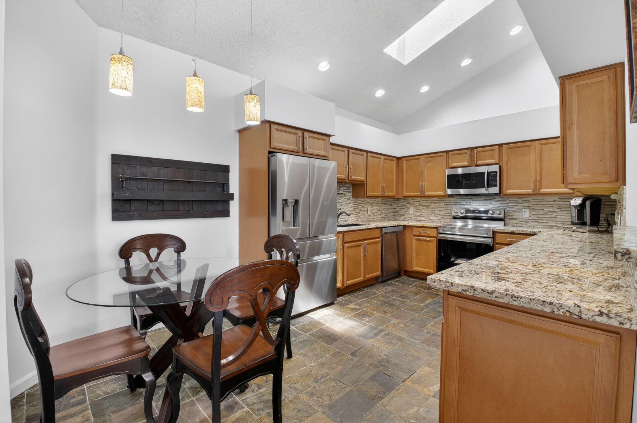 6694 Northwest 26th Way Boca Raton, FL 33496 - Photo 16 of 58 a kitchen with granite countertop a stove a sink a oven a dining table and chairs