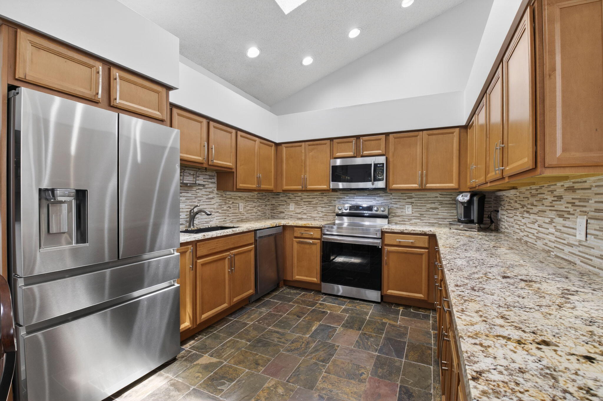 6694 Northwest 26th Way Boca Raton, FL 33496 - Photo 17 of 58 a kitchen with stainless steel appliances granite countertop a refrigerator sink and stove
