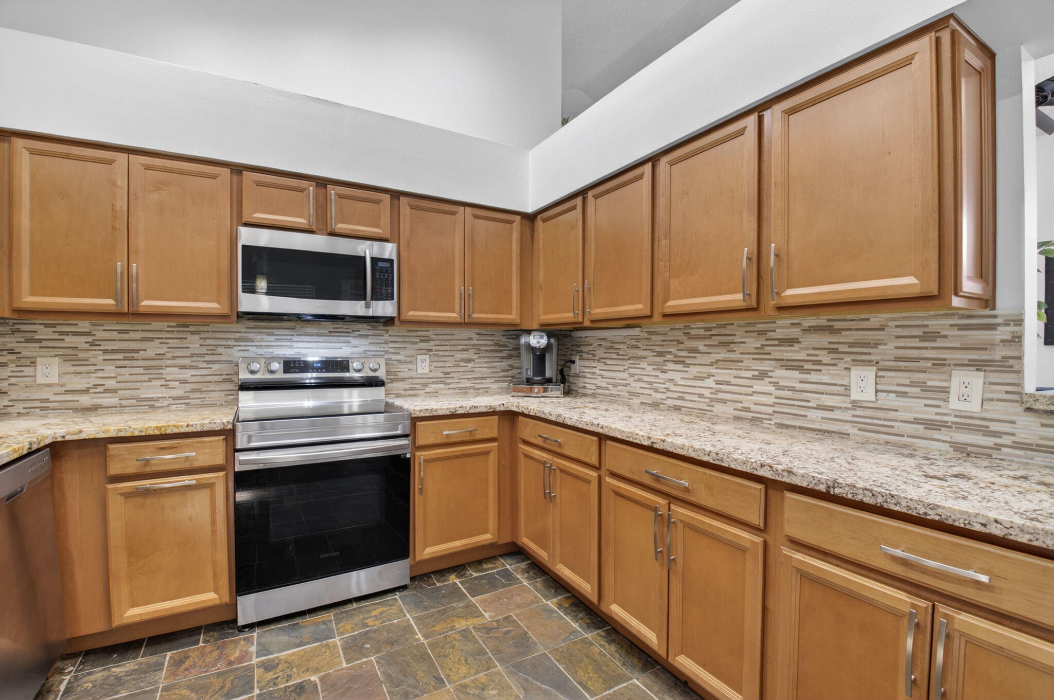 6694 Northwest 26th Way Boca Raton, FL 33496 - Photo 19 of 58 a kitchen with stainless steel appliances granite countertop a sink stove and microwave
