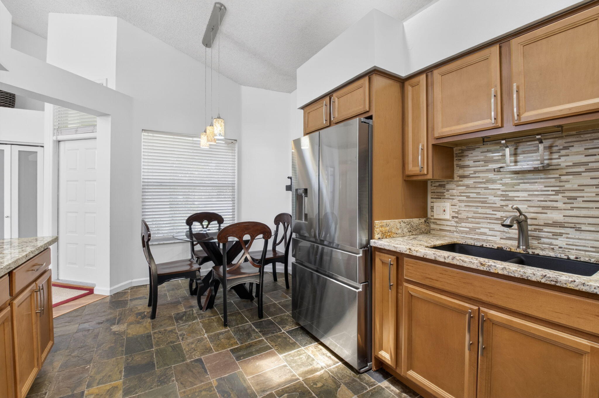 6694 Northwest 26th Way Boca Raton, FL 33496 - Photo 21 of 58 a kitchen with stainless steel appliances granite countertop a refrigerator and a stove top oven