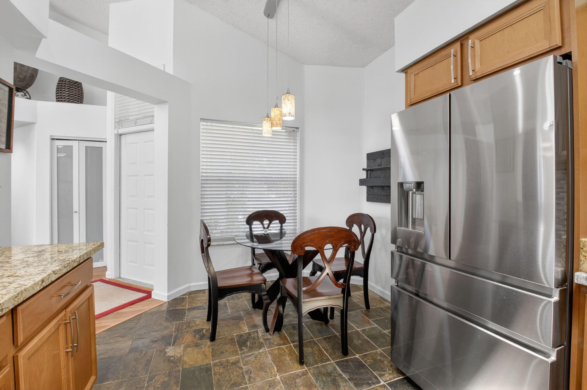 6694 Northwest 26th Way Boca Raton, FL 33496 - Photo 22 of 58 a kitchen with stainless steel appliances granite countertop furniture a refrigerator and a dining table