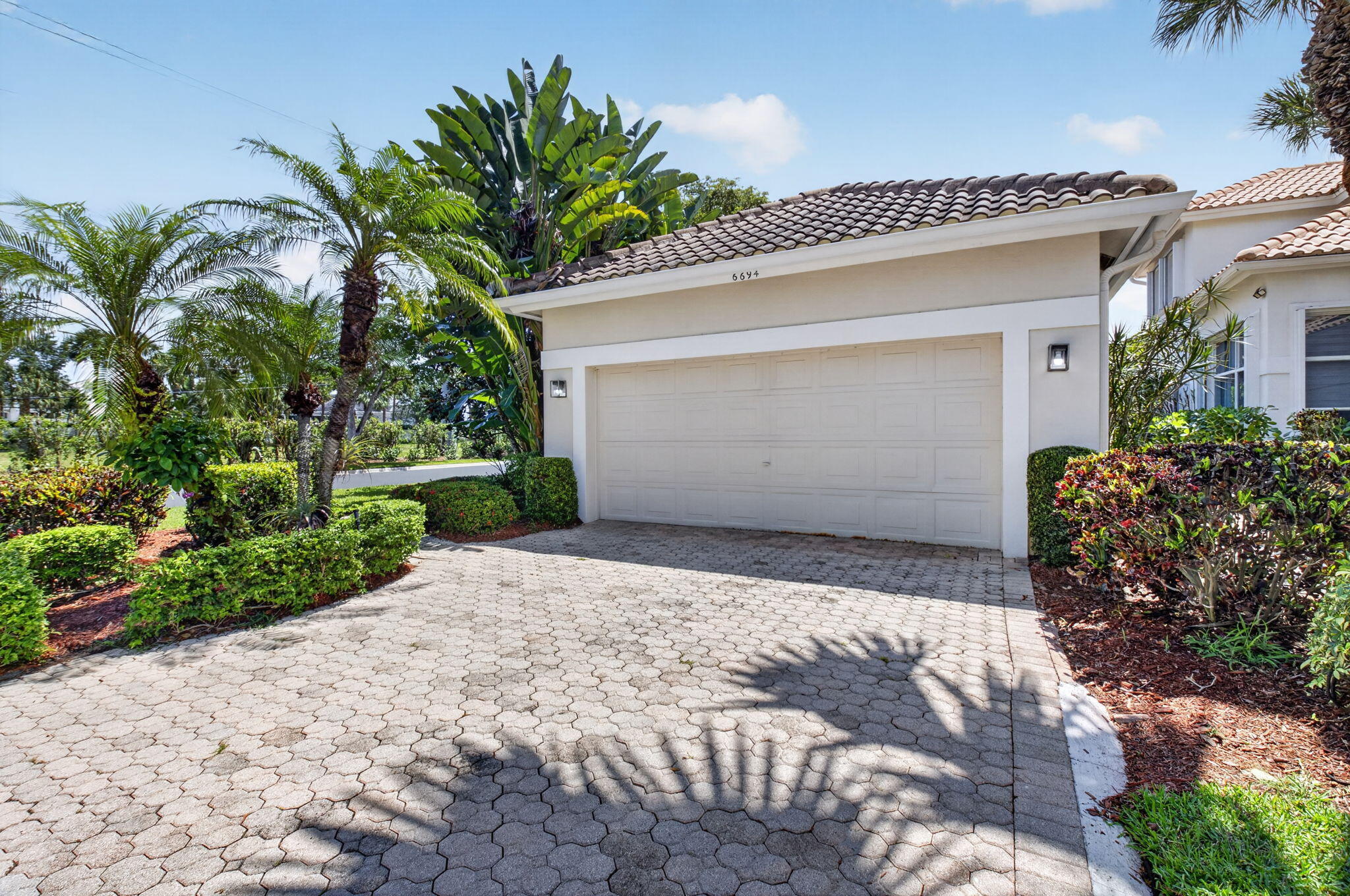 6694 Northwest 26th Way Boca Raton, FL 33496 - Photo 3 of 58 a front view of a house with a yard and garage