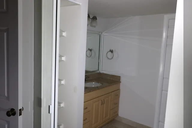 a bathroom with a granite countertop sink and a mirror