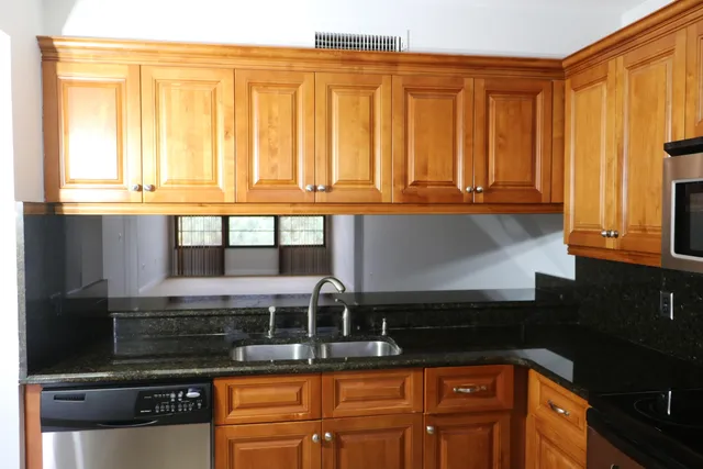 a kitchen with stainless steel appliances granite countertop a stove a sink and a microwave