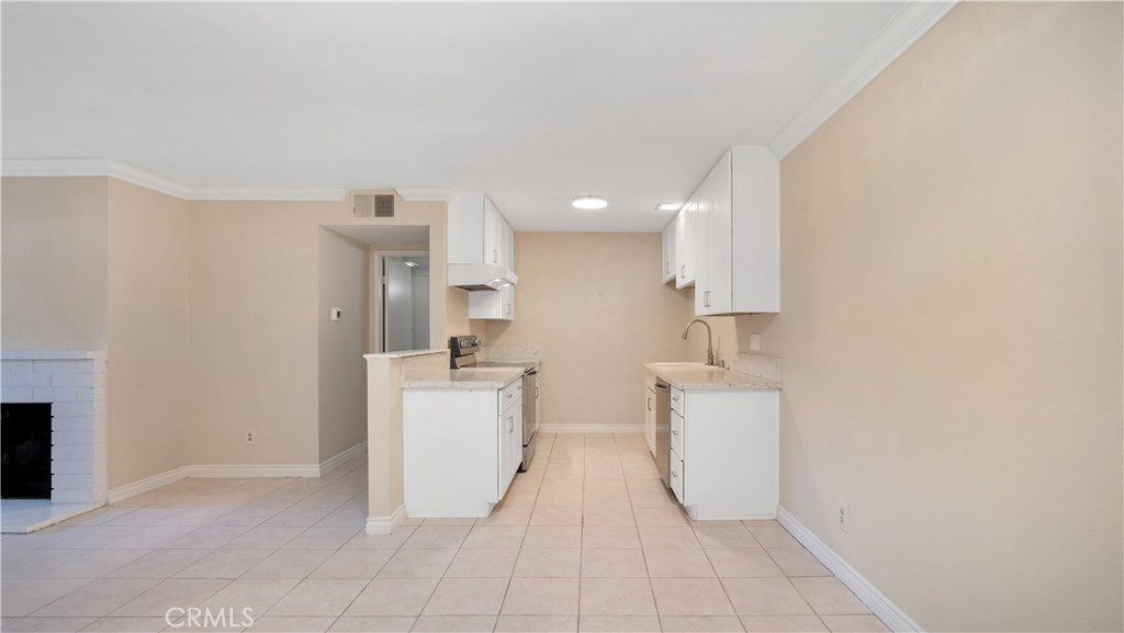 17522 Vandenberg Lane, Unit 3 Tustin, CA 92780 - Photo 18 of 27 a kitchen with a sink a stove top oven and white cabinets