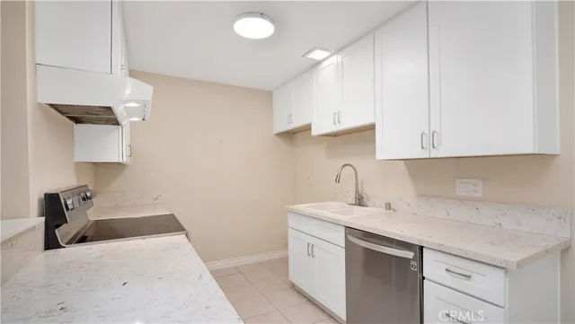 a kitchen with a sink dishwasher and a stove with wooden floor