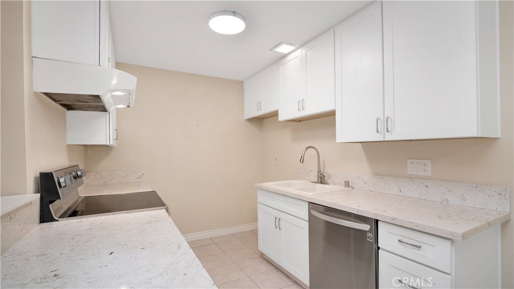 17522 Vandenberg Lane, Unit 3 Tustin, CA 92780 - Photo 19 of 27 a kitchen with a sink dishwasher and a stove with wooden floor