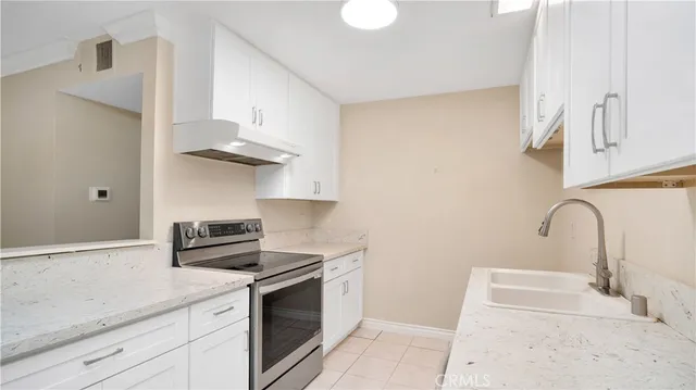 a kitchen with stainless steel appliances granite countertop a sink a stove and a refrigerator