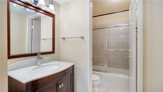a bathroom with a bathtub shower sink vanity and toilet