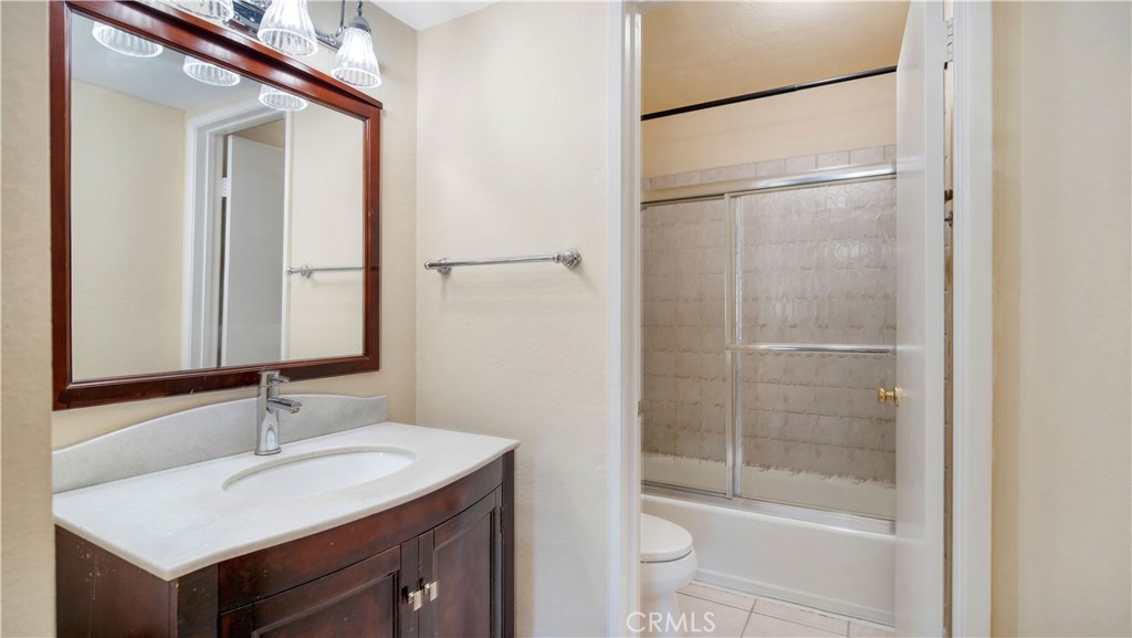 17522 Vandenberg Lane, Unit 3 Tustin, CA 92780 - Photo 23 of 27 a bathroom with a bathtub shower sink vanity and toilet