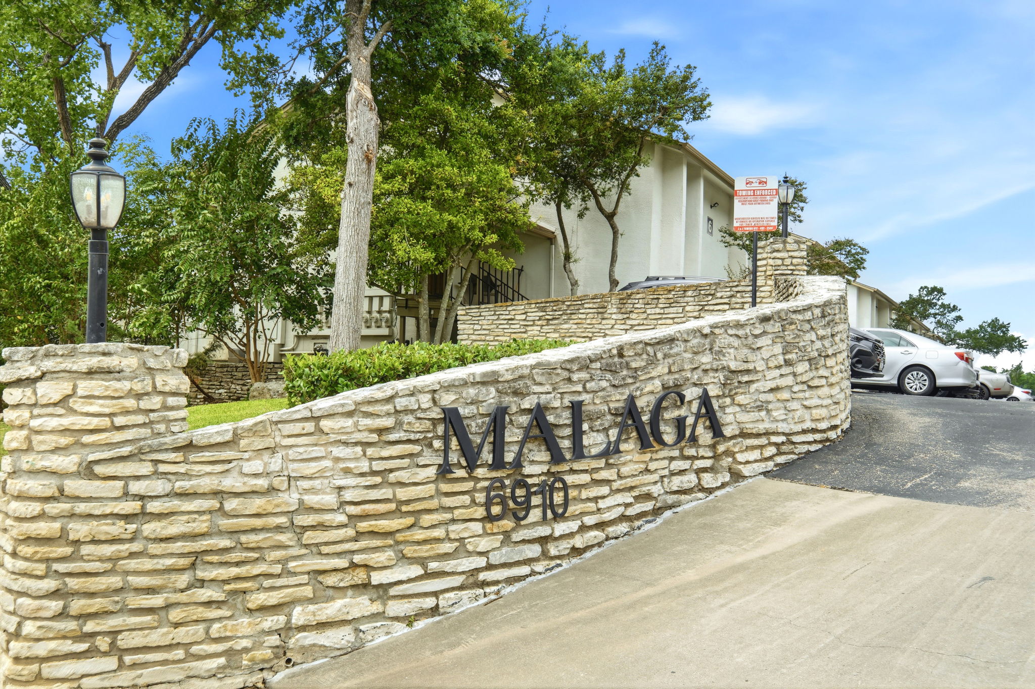 6910 Hart Lane, Unit 912 Austin, TX 78731 - Photo 1 of 36 Stone veneer entrance wall with integrated signage and decorative post lantern