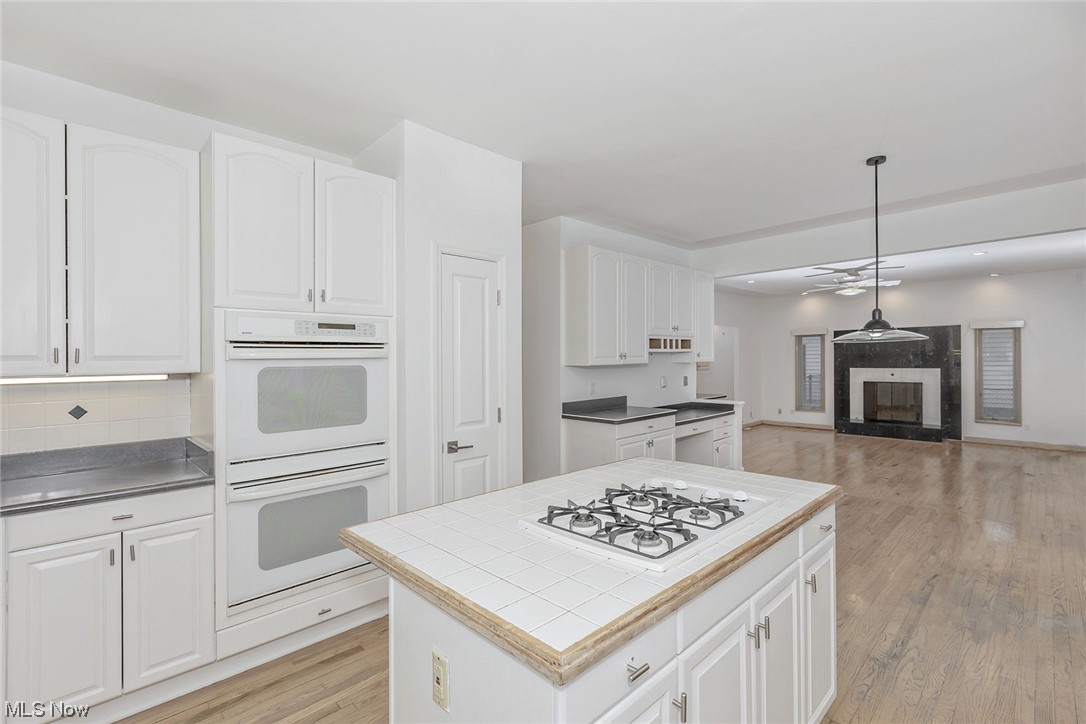 3850 Ellendale Road Moreland Hills, OH 44022 - Photo 13 of 39 Kitchen featuring double oven white appliances, hardwood flooring and white cabinetry.