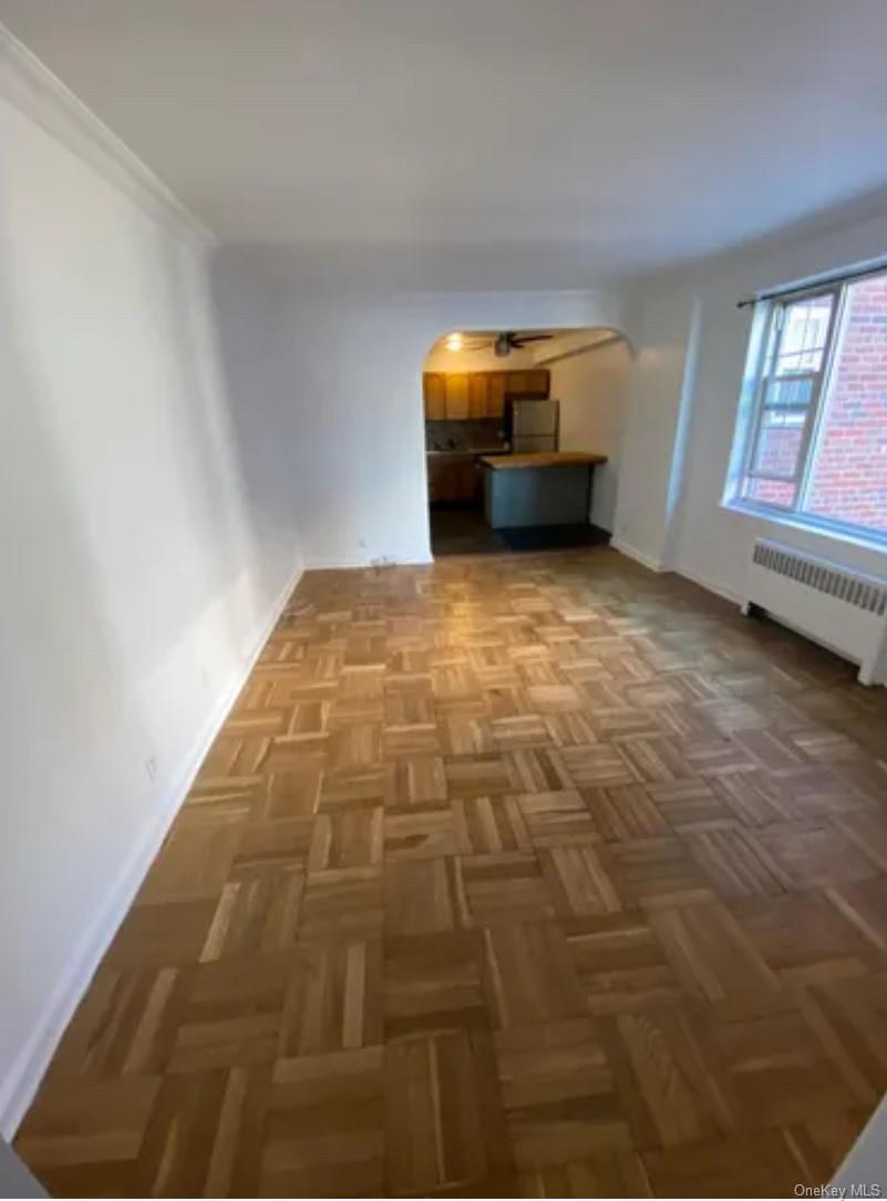220 Pelham Road, Unit 3F New Rochelle, NY 10805 - Photo 3 of 25 Unfurnished living room with radiator heating unit, arched walkways, and baseboards