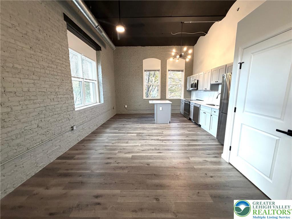 810 Monocacy Street, Unit 303 Bethlehem, PA 18018 - Photo 16 of 24 a view of a hallway with wooden floor and a kitchen