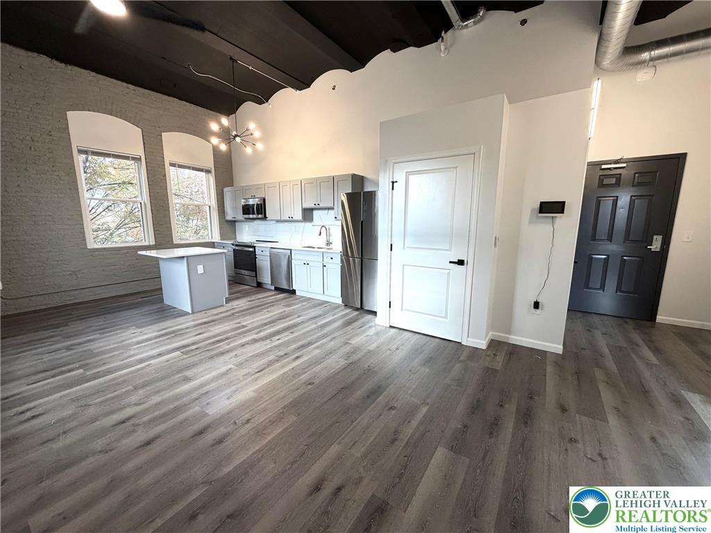 810 Monocacy Street, Unit 303 Bethlehem, PA 18018 - Photo 3 of 24 a open kitchen with a sink dishwasher refrigerator and wooden floor