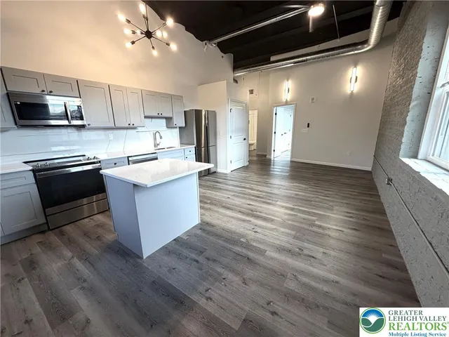 a kitchen with stainless steel appliances kitchen island granite countertop a stove and a refrigerator