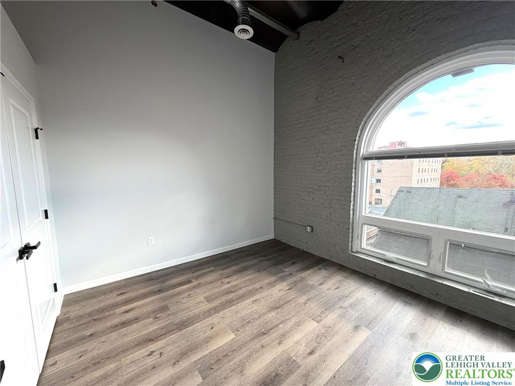 810 Monocacy Street, Unit 303 Bethlehem, PA 18018 - Photo 6 of 24 an empty room with wooden floor and windows