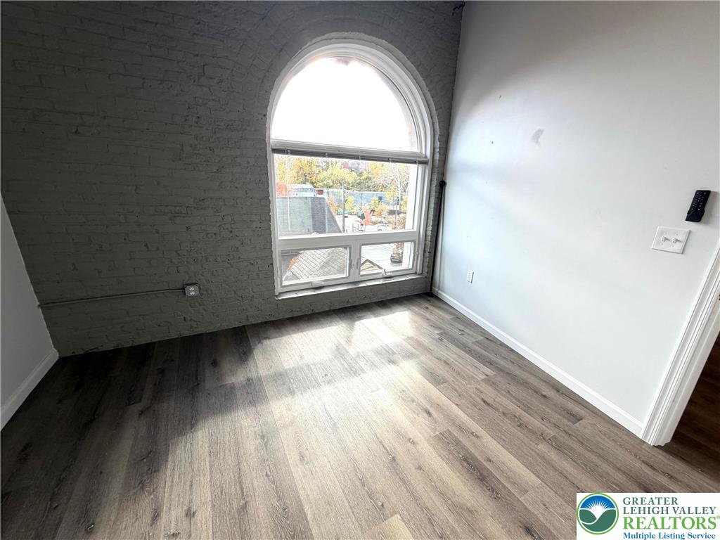 810 Monocacy Street, Unit 303 Bethlehem, PA 18018 - Photo 7 of 24 an empty room with wooden floor and windows