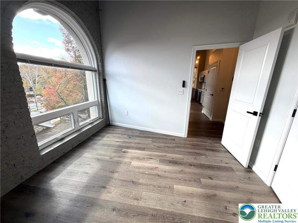 810 Monocacy Street, Unit 303 Bethlehem, PA 18018 - Photo 8 of 24 an empty room with wooden floor and windows