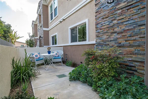 a view of a patio with table and chairs and potted plants