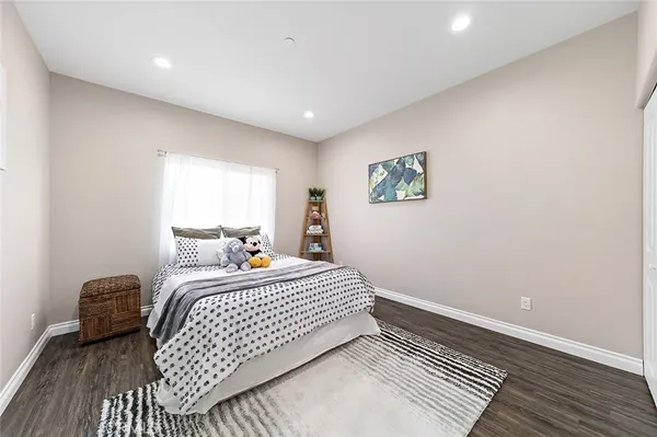 a view of a bedroom with wooden floor and furniture