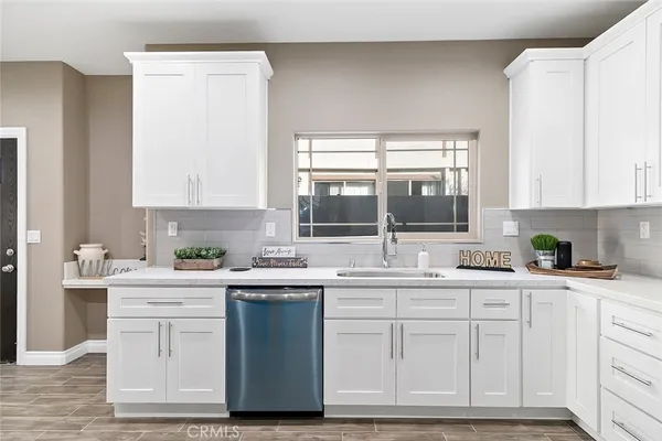 a kitchen with stainless steel appliances granite countertop a sink and cabinets with wooden floor